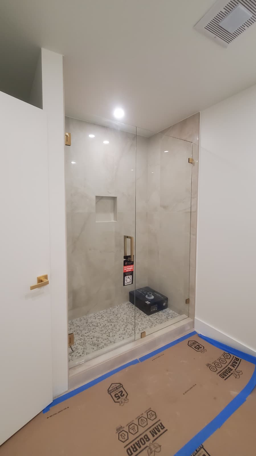 Clear glass shower door with sleek handle and modern design.
