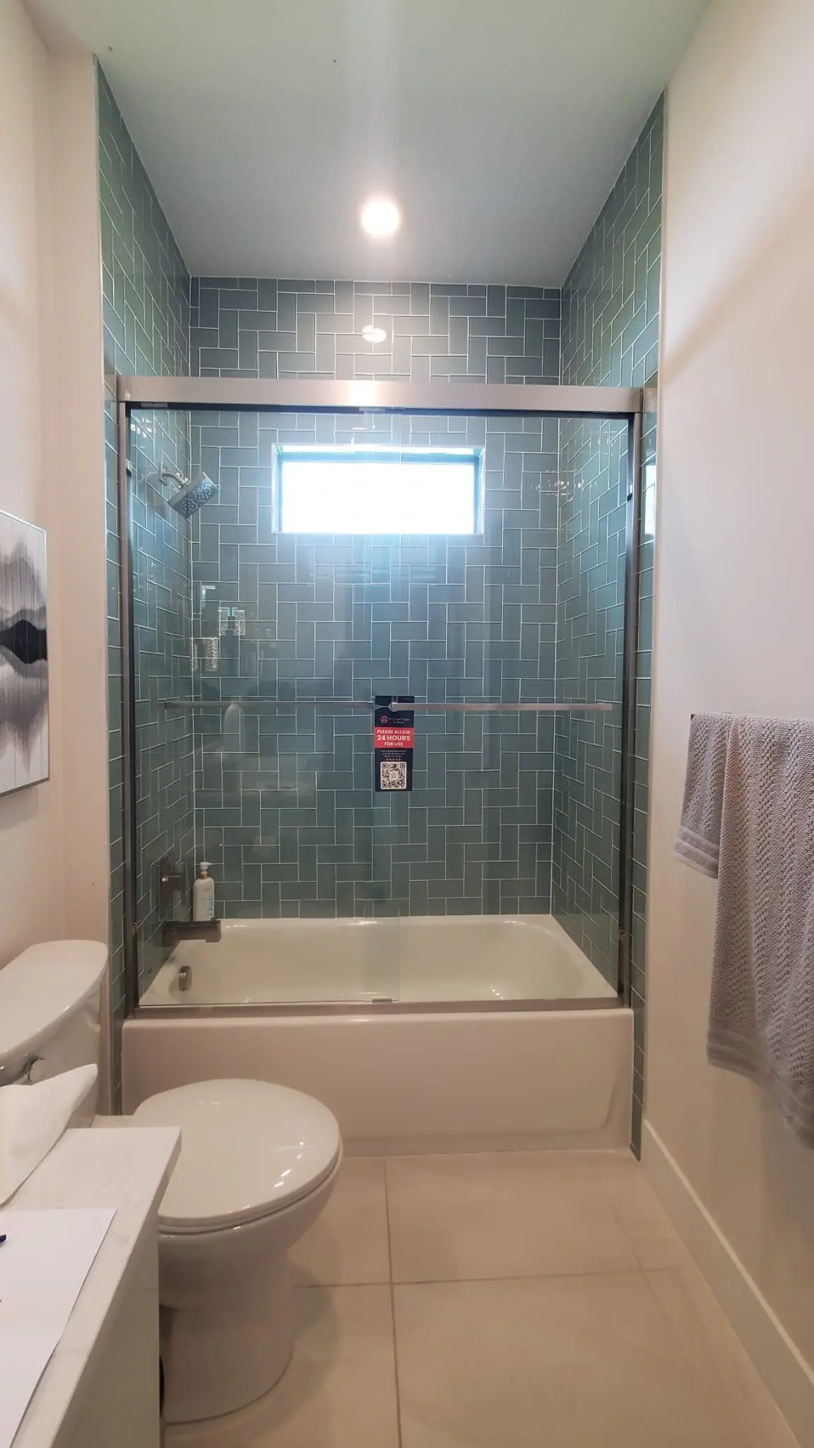 Clear glass shower door with chrome frame in modern bathroom.