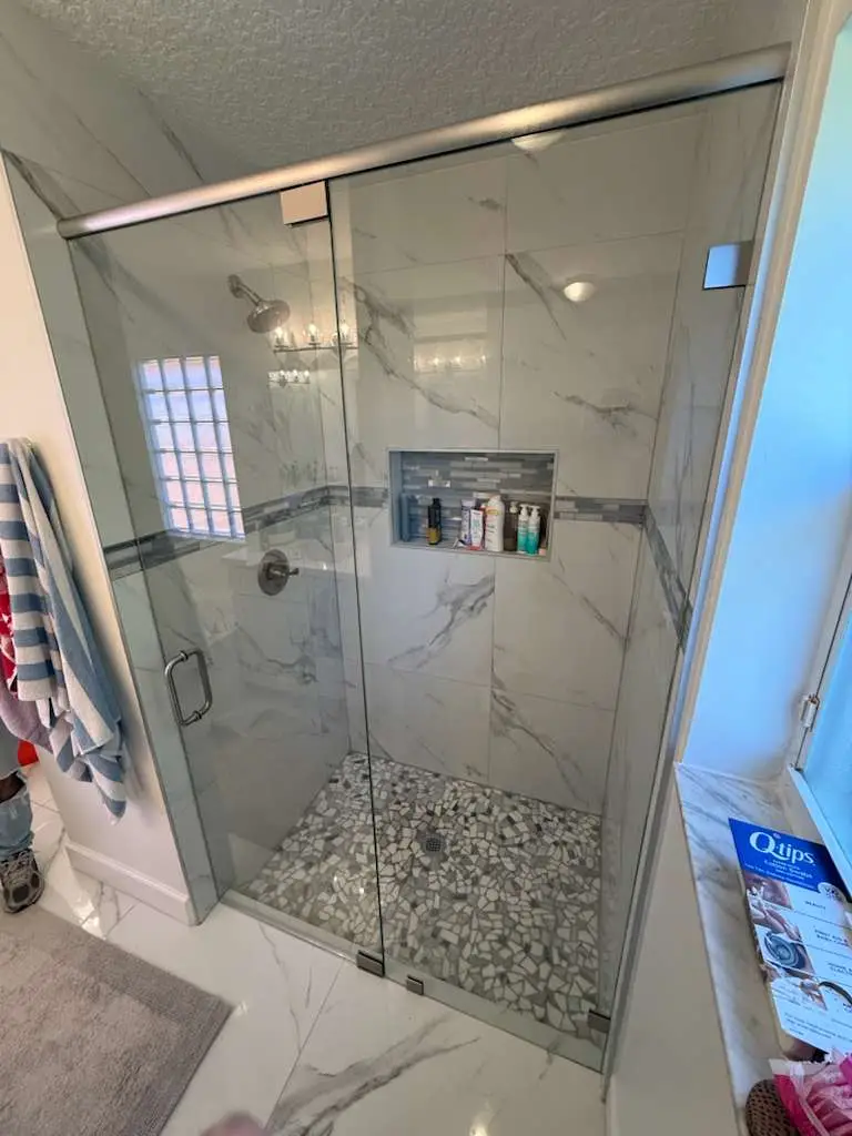 High-quality glass shower enclosure with mosaic tile floor for modern bathroom style. Elegant and durable glass design.