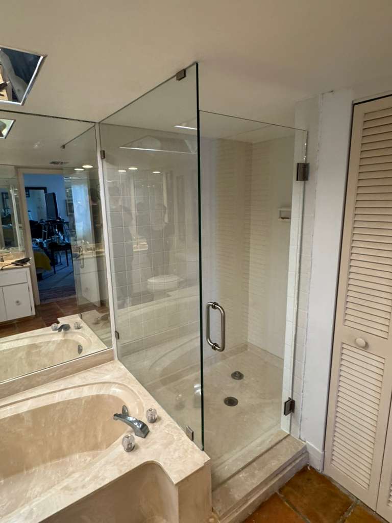 High-quality glass shower door with stainless steel handle accessory.
