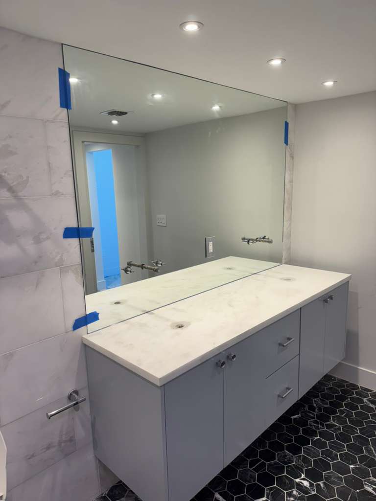 High-quality bathroom mirror reflected in modern vanity with marble countertop, enhancing space aesthetics.