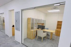 Frameless glass office front with swing door at Related Ross in West Palm Beach